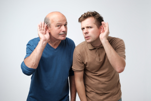 Two,caucasian,men,hearing,with,hand,on,ear,isolated,on