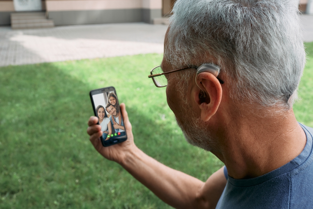 Senior,man,with,a,hearing,aid,behind,the,ear,communicates