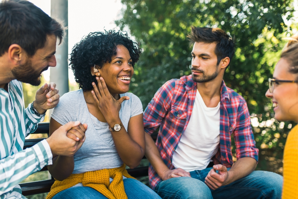 Woman,with,ear,hearing,problem,having,fun,with,her,friends