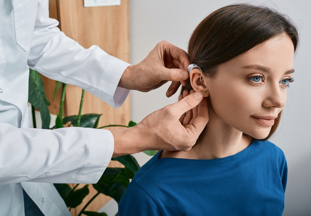 Installation,hearing,aid,on,woman's,ear,at,hearing,clinic,,close Up,